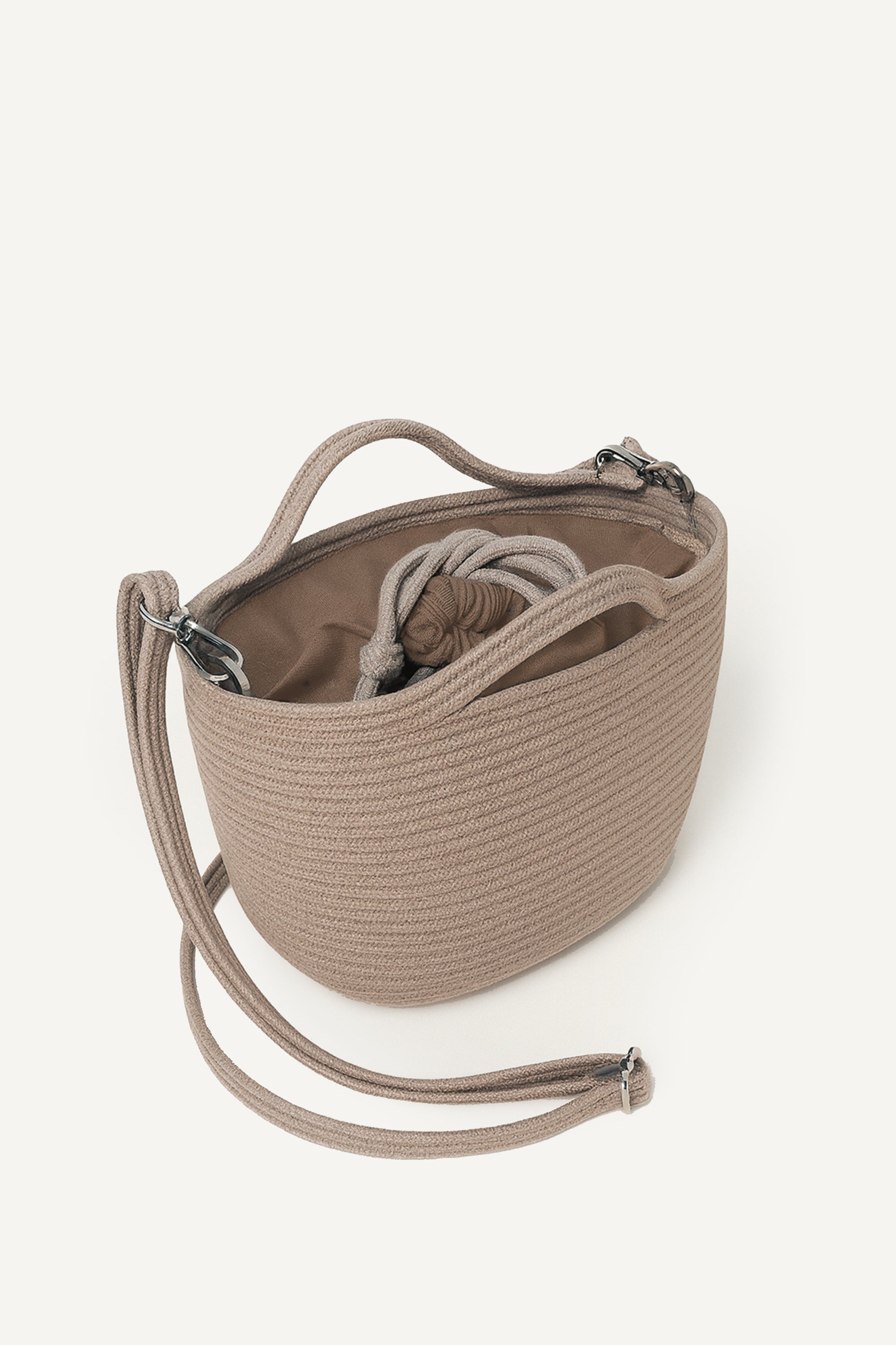 Top side view of the beige capri cotton crochet crossbody bag with an adjustable strap and secure drawstring closure