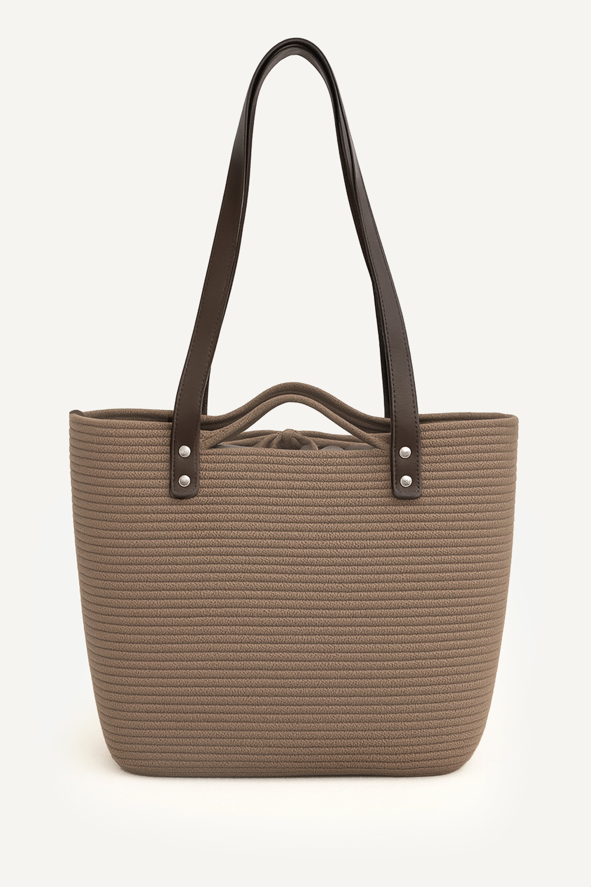 Front view of the brown woven capri tote bag with leather handles on a white background