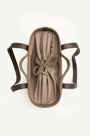 Top view of the brown woven capri tote bag with leather handles on a white background