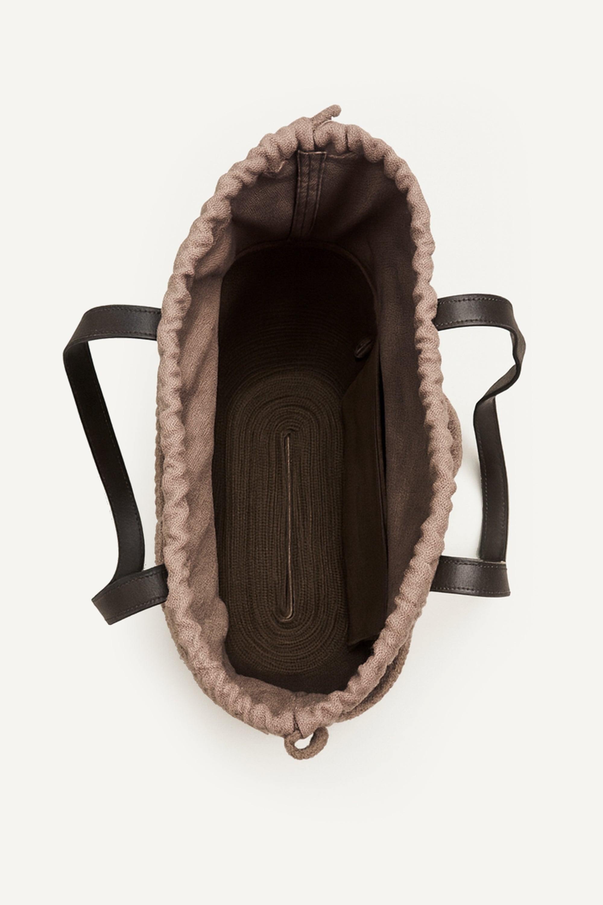 Top open view of the brown woven capri tote bag with leather handles on a white background