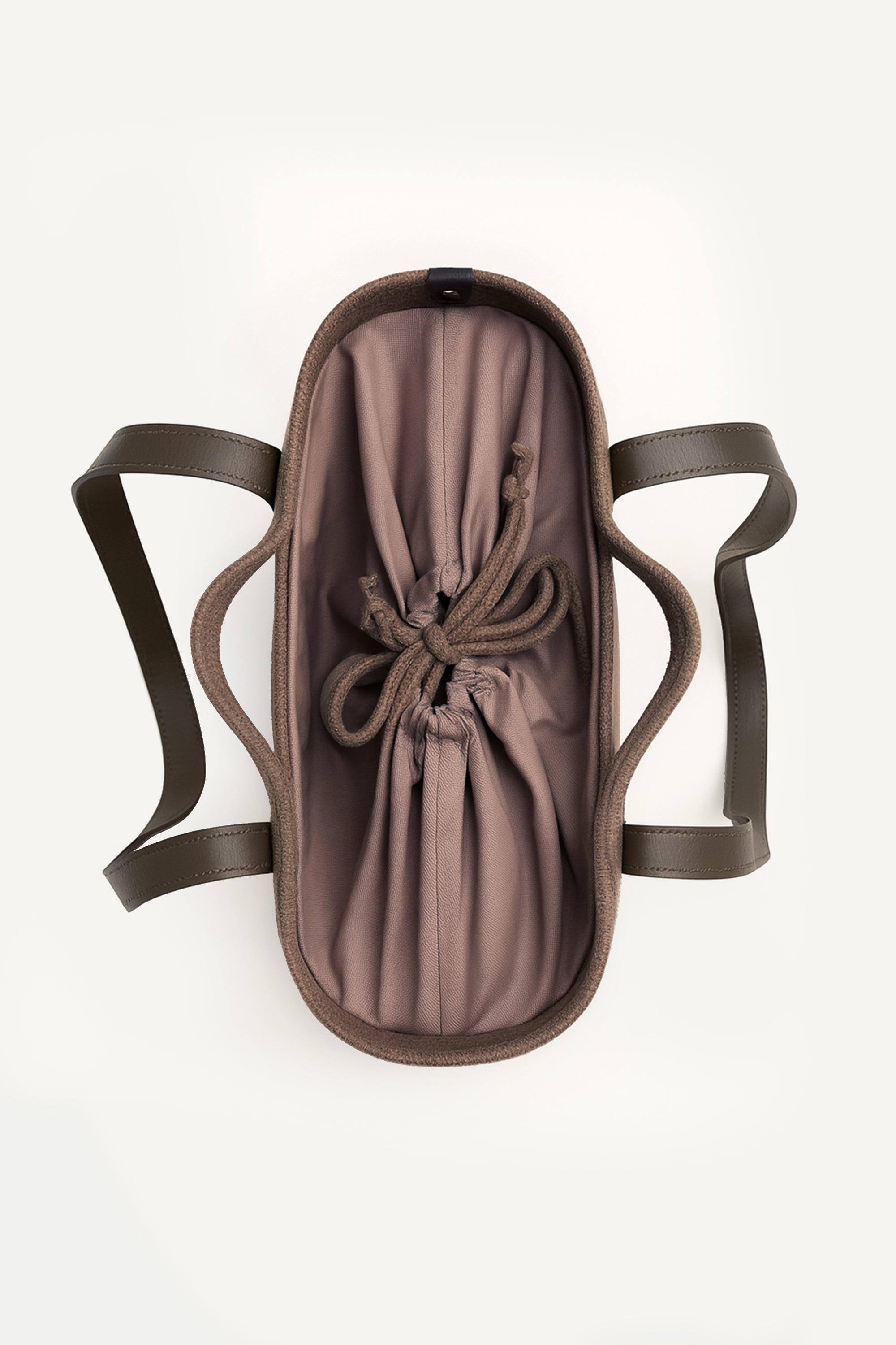 Top view of the brown woven capri tote bag with leather handles on a white background