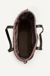 Top open view of the brown woven capri tote bag with leather handles on a white background