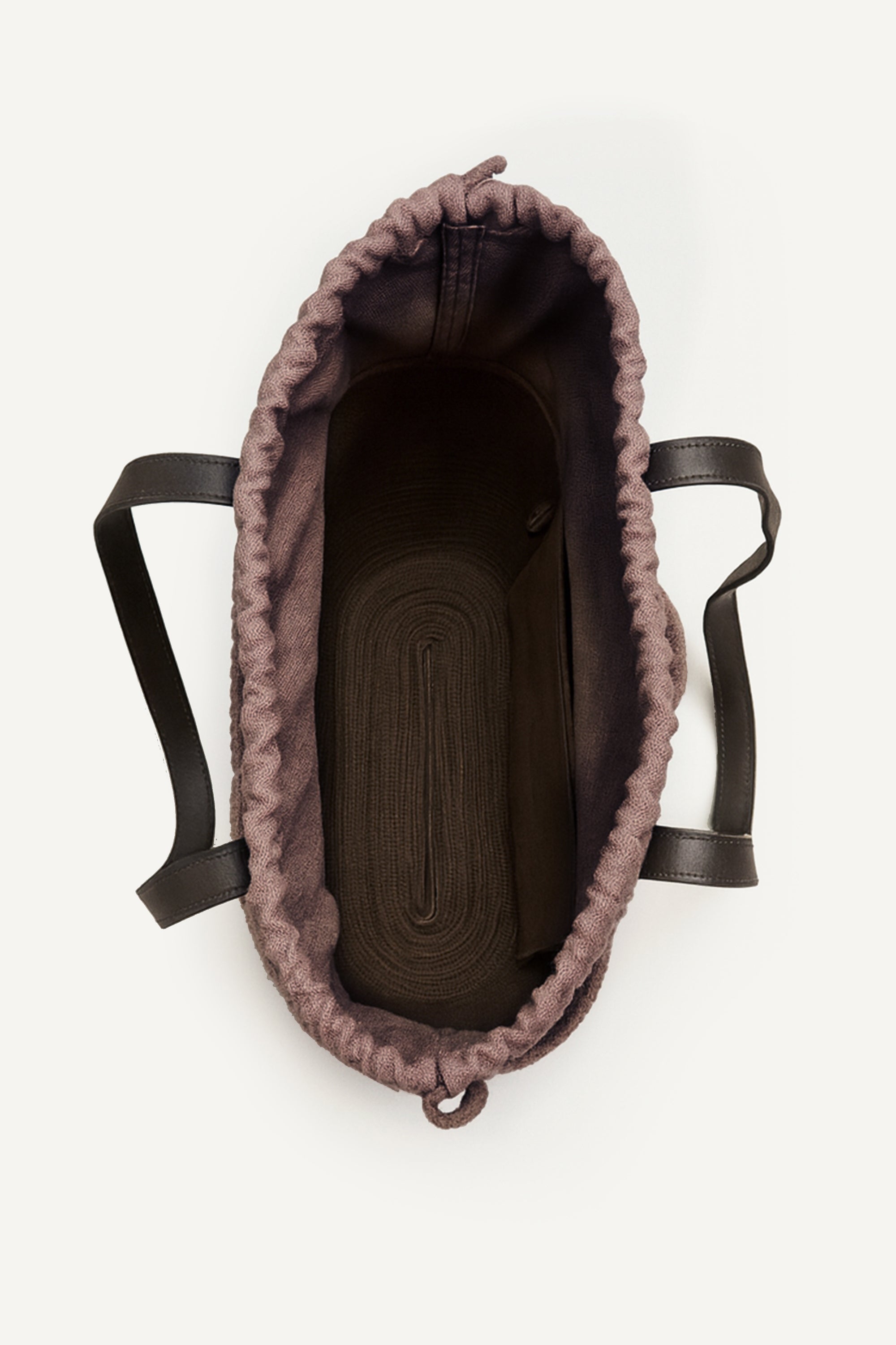 Top open view of the brown woven capri tote bag with leather handles on a white background