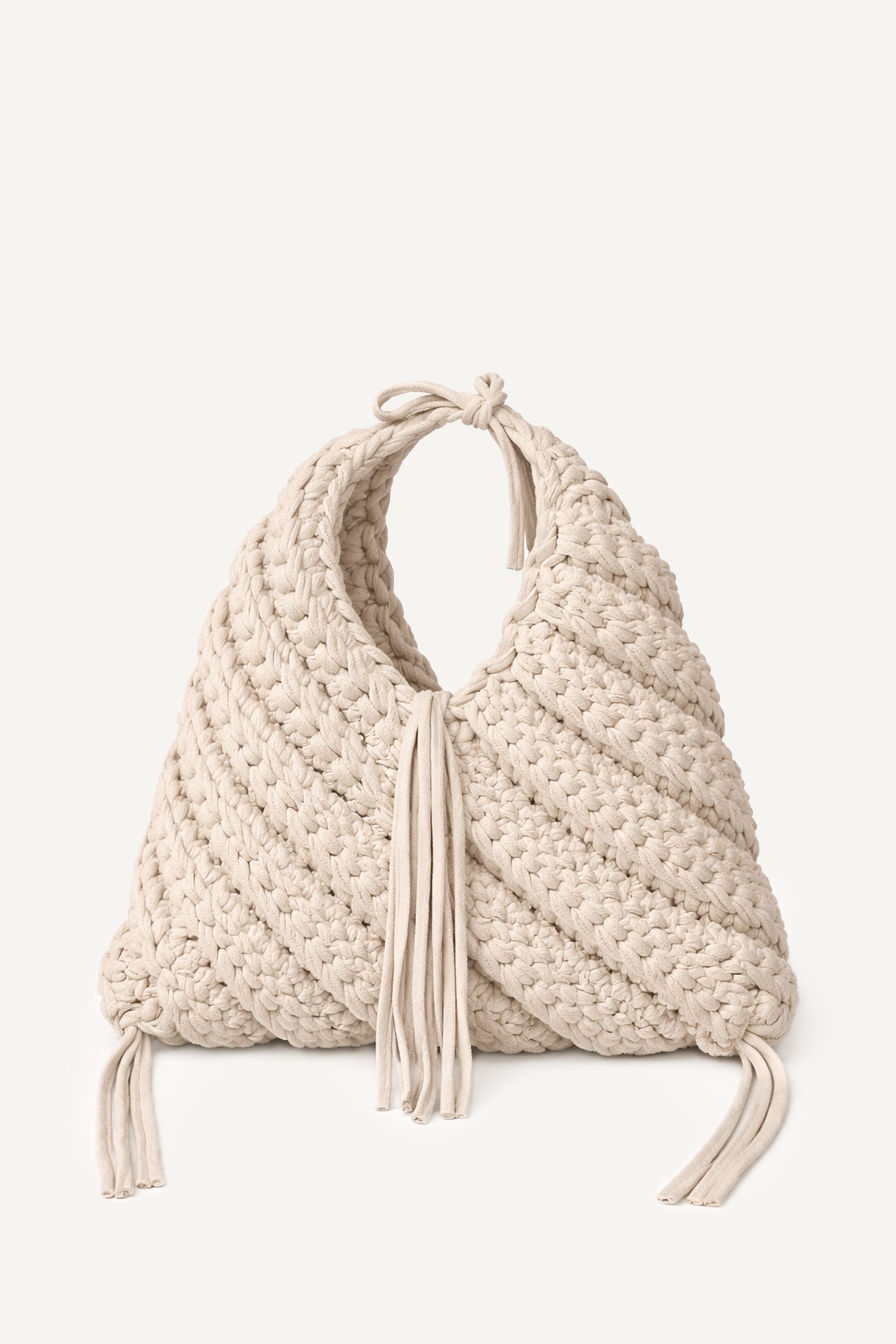 Front view of Lviv crochet beige woven handbag with tassels on a light beige background