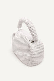 Angled back view of the woven white assos crochet top-handle bag with fringe detailing