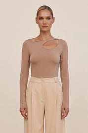 Front view of a woman wearing the beige Cut Longsleeve top by FemeAdor with fitted silhouette and front cutout detail