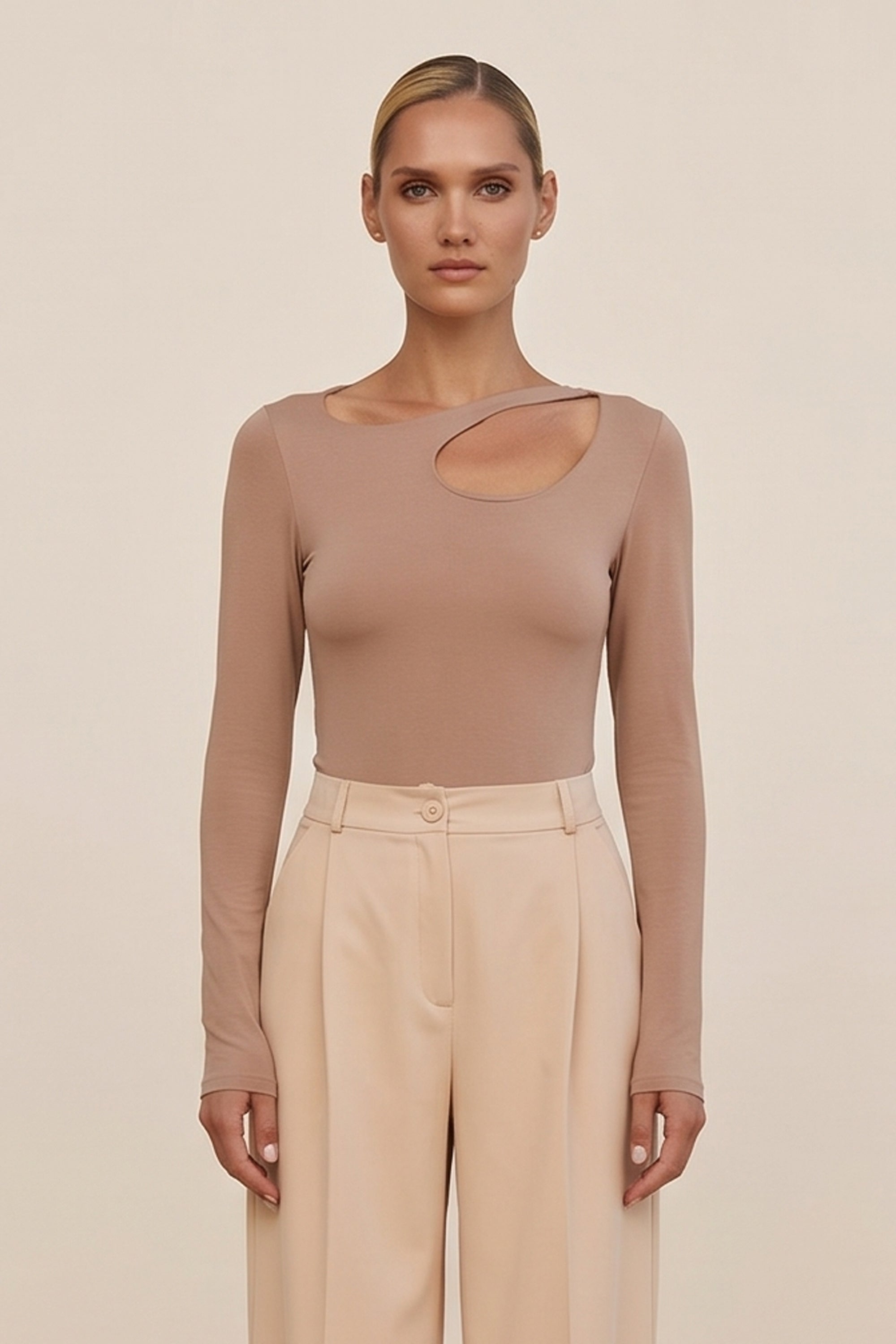 Front view of a woman wearing the beige Cut Longsleeve top by FemeAdor with fitted silhouette and front cutout detail
