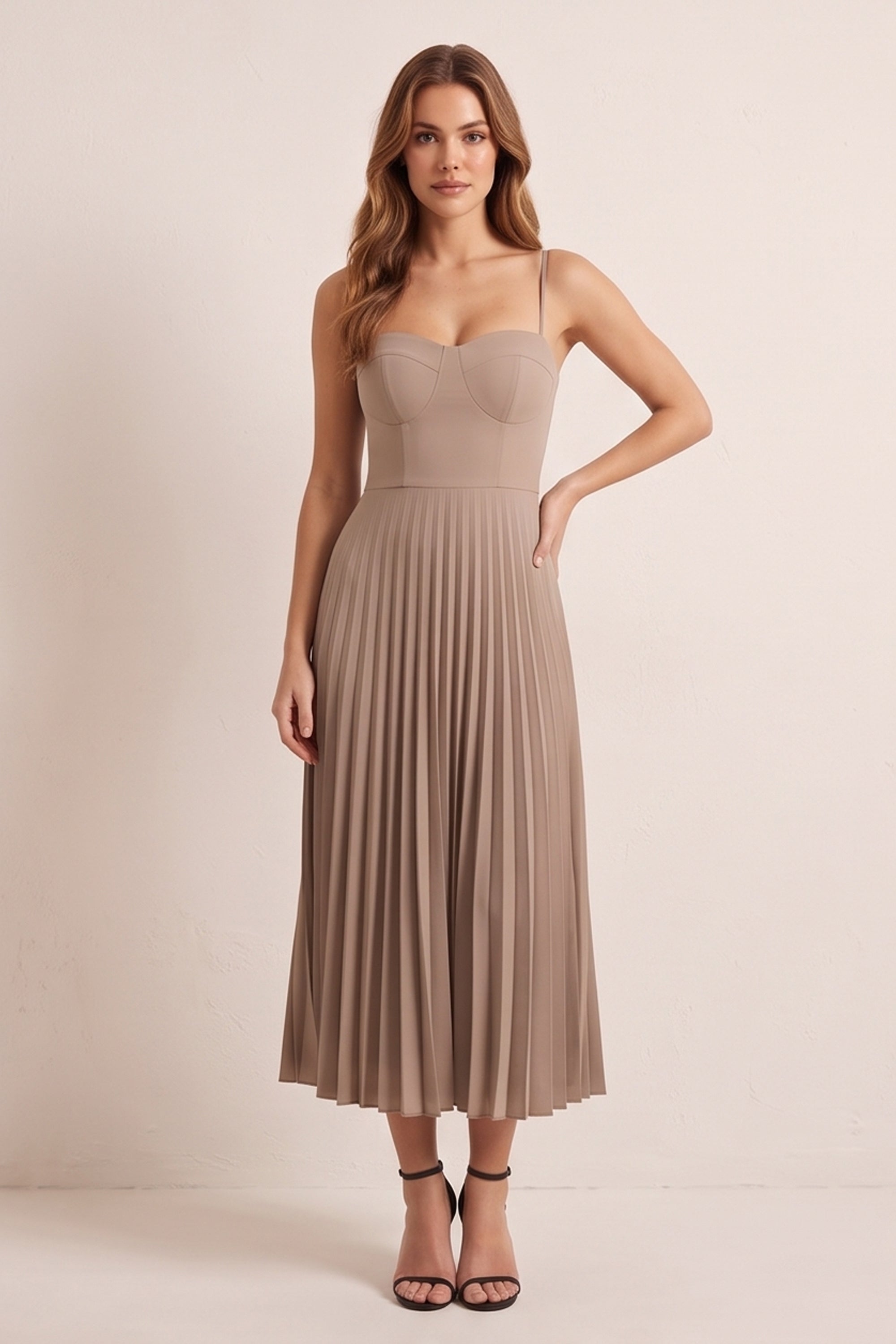 Front view of a woman wearing the beige Eclipse Demi Dress by FemeAdor featuring a structured corset top and a flowing pleated midi skirt perfect for formal and casual events