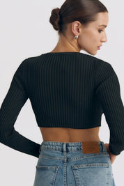 Back view of a woman wearing the black Cropped Longsleeve Top by FemeAdor featuring a flattering cropped cut and a cozy fitted ribbed knit design