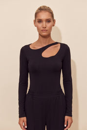 Front view of a woman wearing the black Cut Longsleeve top by FemeAdor with fitted silhouette and front cutout detail