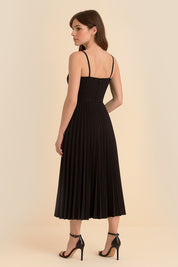 Back view of the Eclipse Demi Dress by FemeAdor in black featuring a structured corset top and a flowing pleated midi skirt perfect for formal and casual events