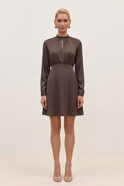 Front view of a woman wearing the black floral mini dress by FemeAdor with delicate floral print, stand-up collar, and flattering fit