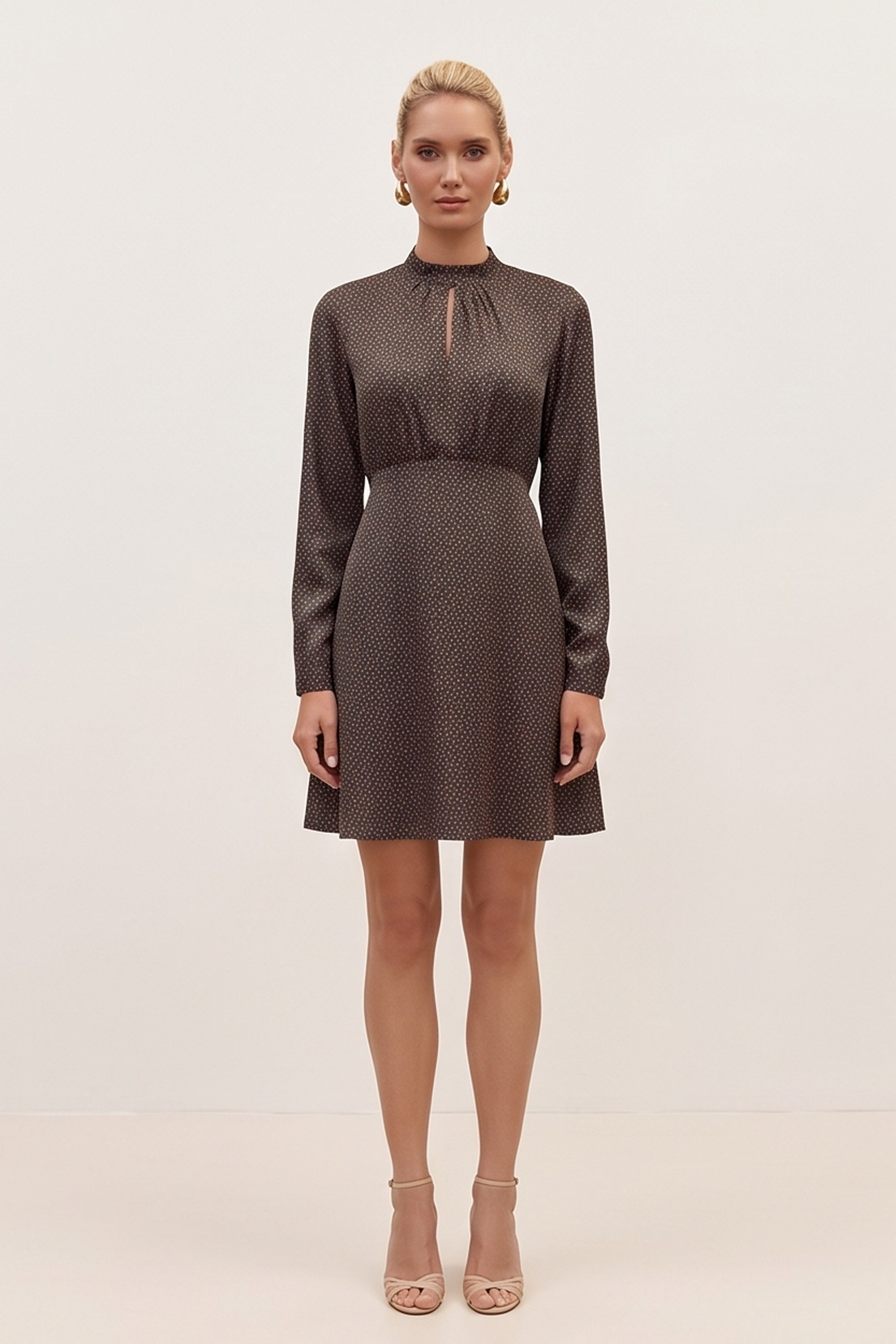 Front view of a woman wearing the black floral mini dress by FemeAdor with delicate floral print, stand-up collar, and flattering fit