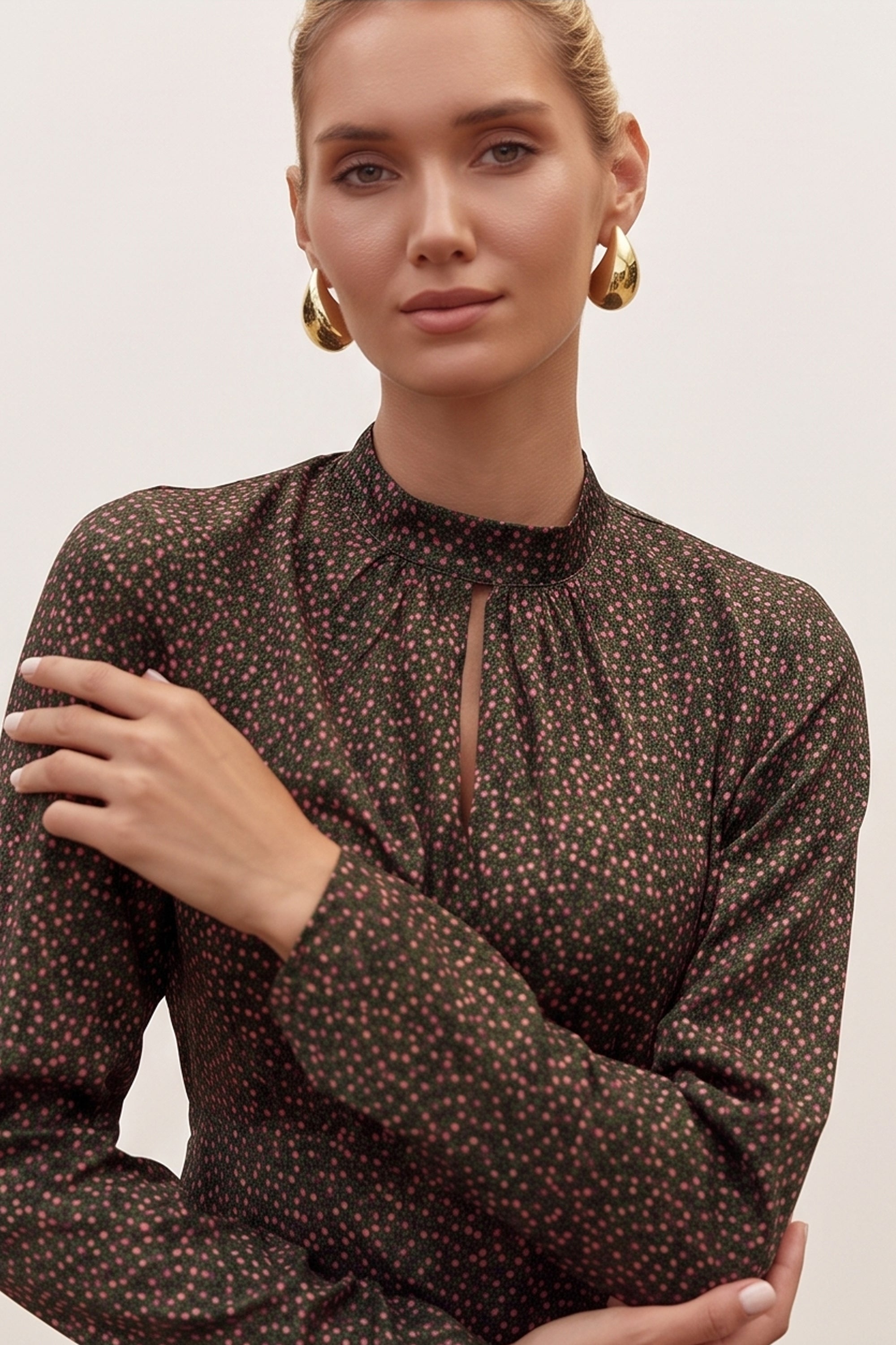Close up view of a woman wearing the black floral mini dress by FemeAdor with delicate floral print, stand-up collar, and flattering fit