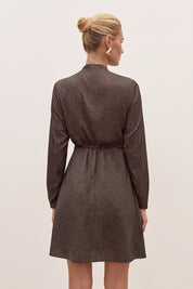 Back view of a woman wearing the black floral mini dress by FemeAdor with delicate floral print, stand-up collar, and flattering fit