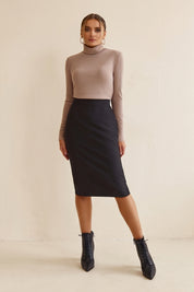 Woman wearing Liaison Skirt by FemeAdor in black featuring a sleek, figure-flattering midi silhouette, ideal for both professional and casual styling