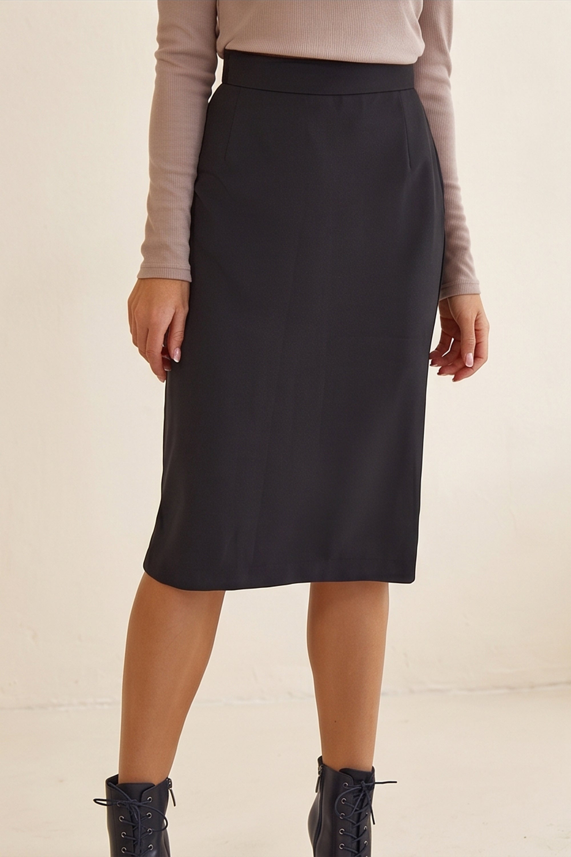 Close up of Liaison Skirt by FemeAdor in black featuring a sleek, figure-flattering midi silhouette, ideal for both professional and casual styling