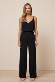 Front view of a woman wearing black Moda Trousers by FemeAdor featuring a high-waisted, wide-leg tailored fit for modern styling