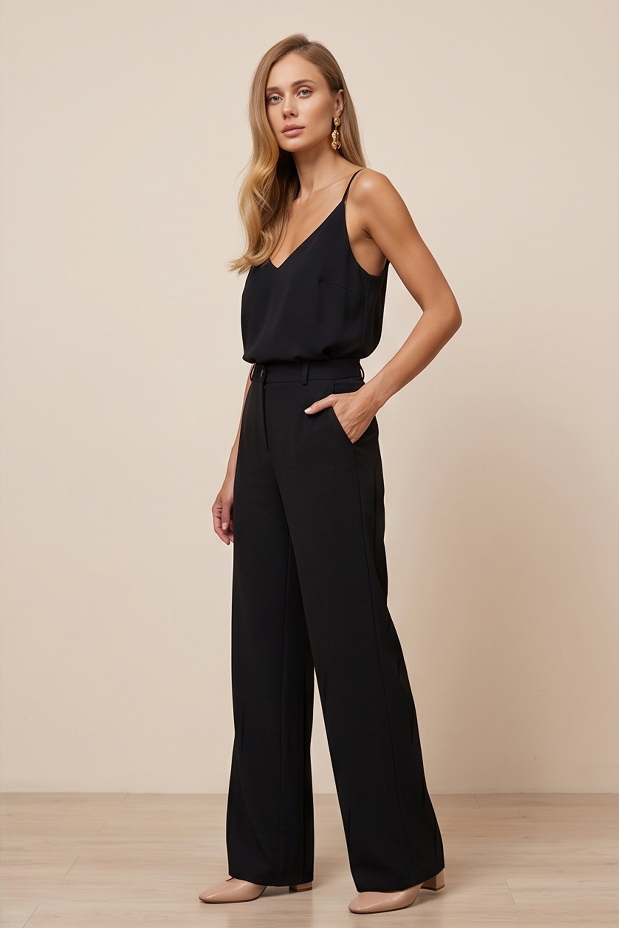 Side view of a woman wearing black Moda Trousers by FemeAdor featuring a high-waisted, wide-leg tailored fit for modern styling