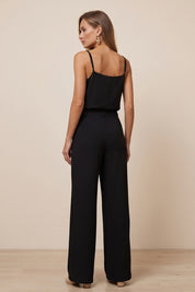 Back view of a woman wearing black Moda Trousers by FemeAdor featuring a high-waisted, wide-leg tailored fit for modern styling