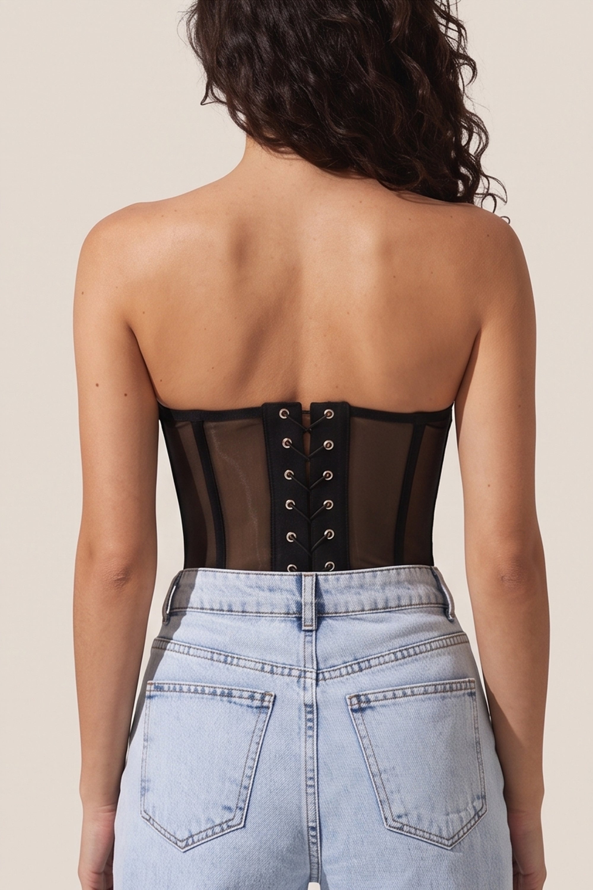 Back view of a woman wearing the black Timeless Corset by Femeador with a structured fit, lace-up back and romantic silhouette