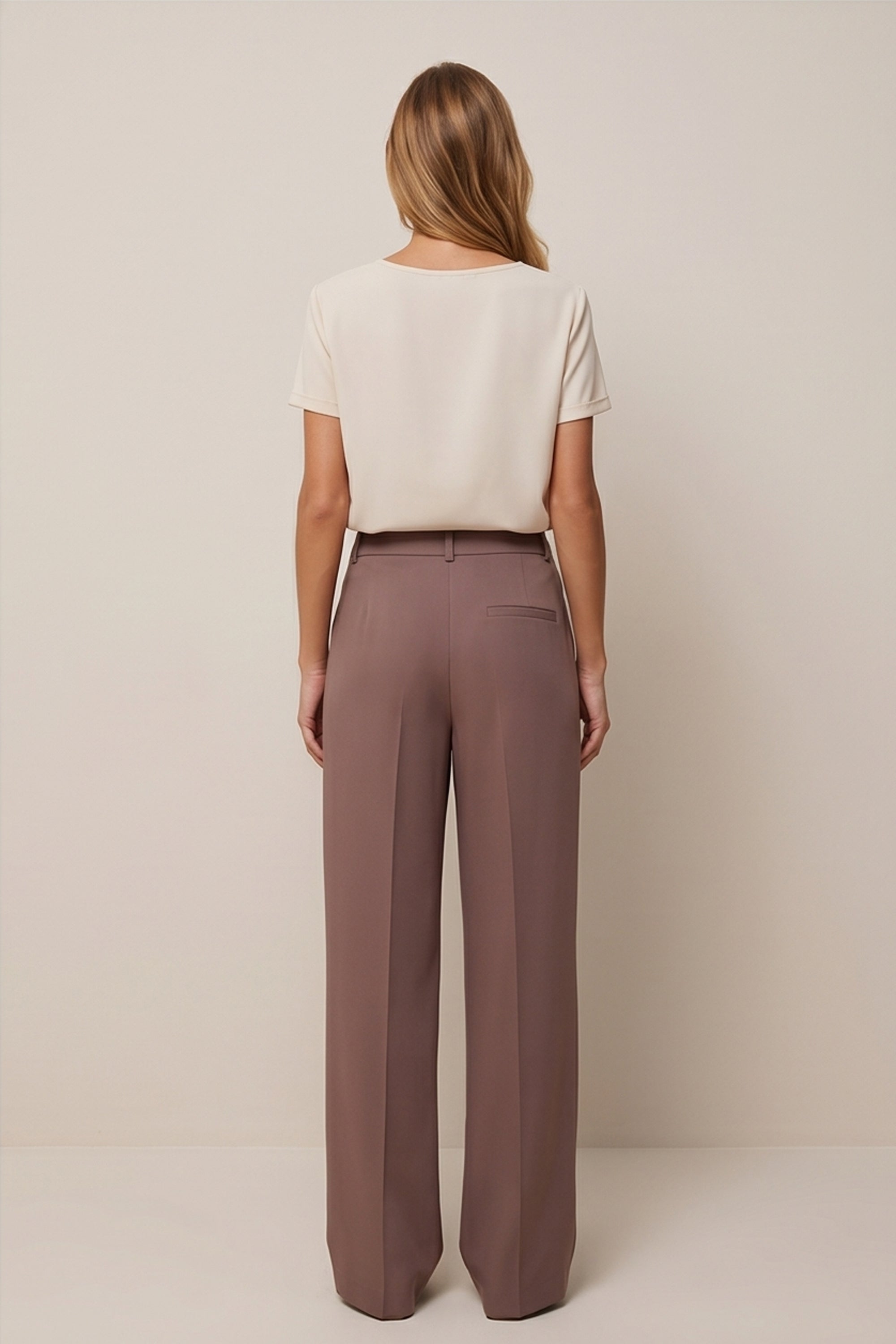 Back view of a woman wearing the brown Continental Trousers by FemeAdor with high-waisted tailored fit, ideal for office or casual wear
