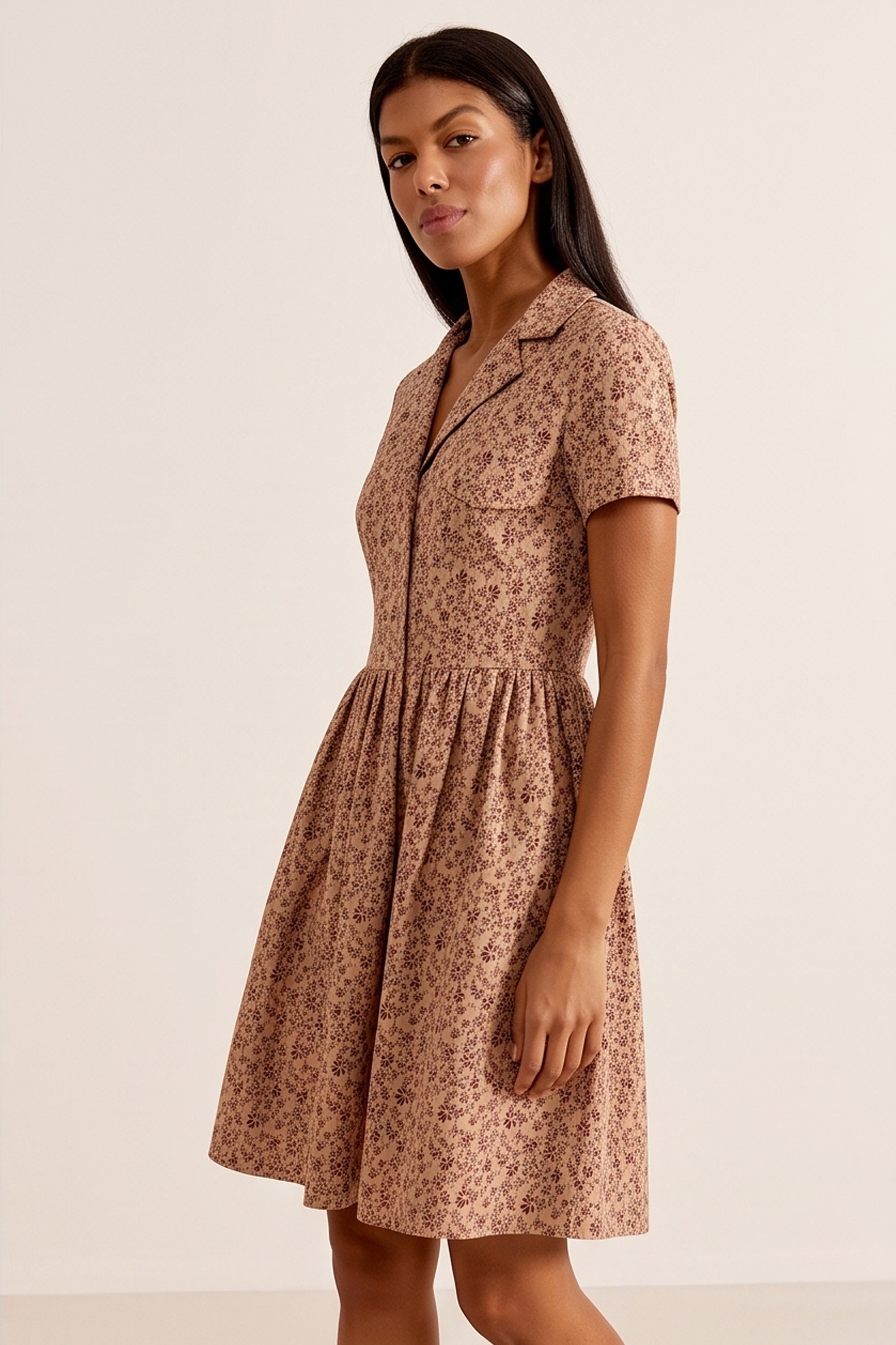 Side view of a woman wearing the brown Mocha Mini Dress in floral linen with short sleeves and collared neck design by FemeAdor