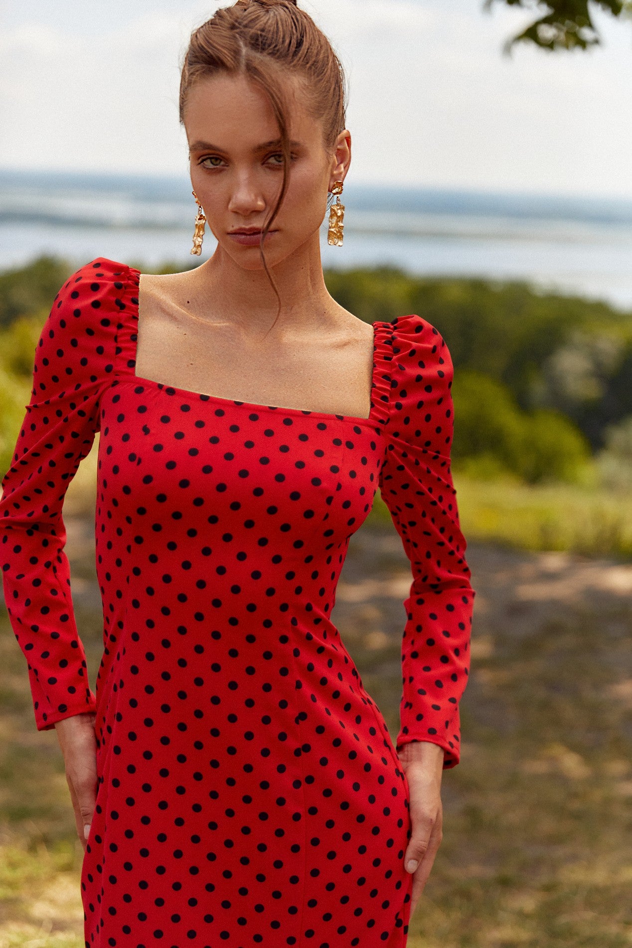 Close up view of the Celestra Midi Dress by FemeAdor in red featuring a flattering fit-and-flare silhouette and timeless polka dot pattern