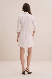 Back view of a woman wearing the cream vespera mini dress-jacket by FemeAdor