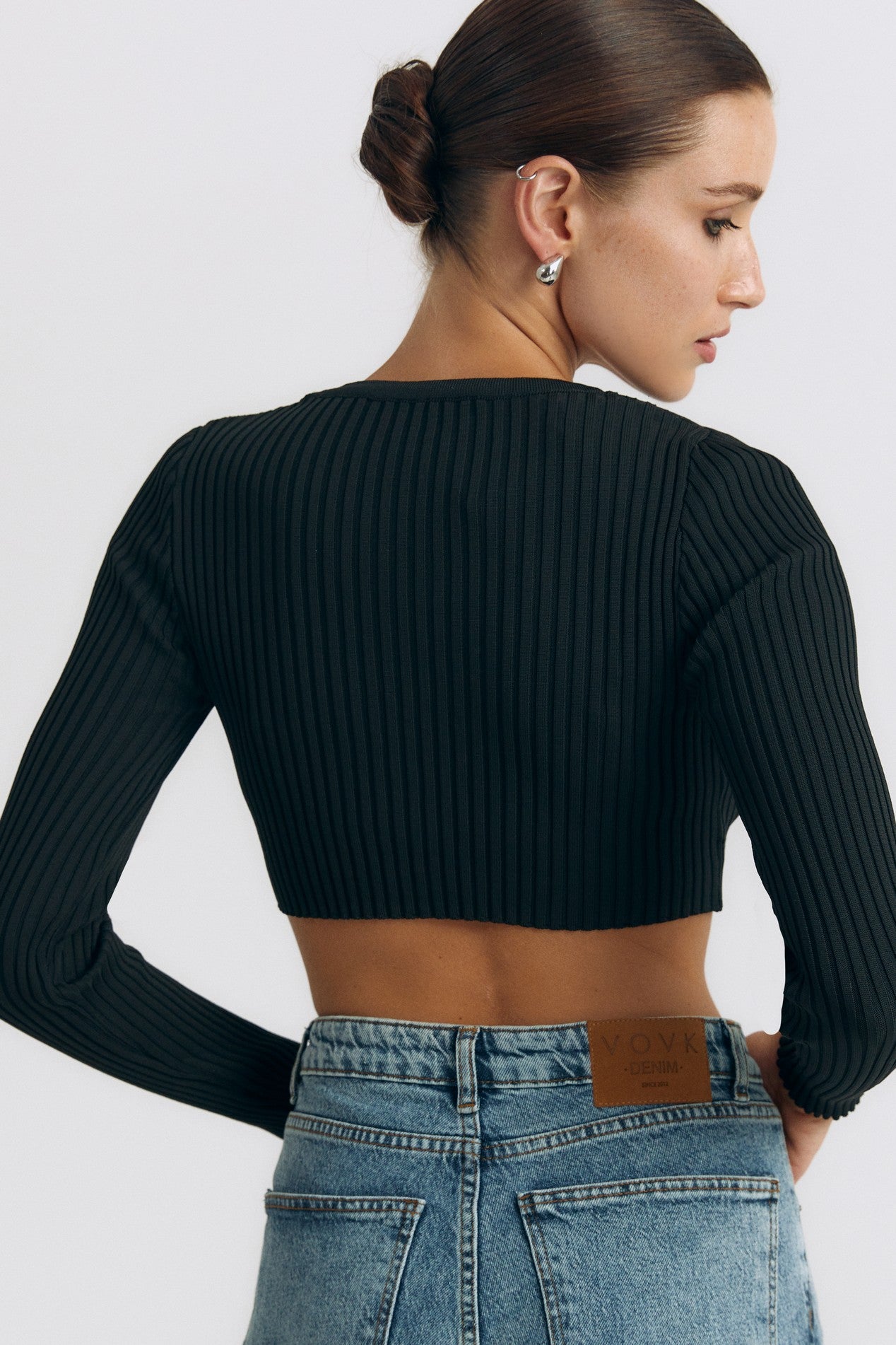 Back view of the Cropped Longsleeve by FemeAdor in black featuring a flattering cropped cut and a cozy fitted ribbed knit design