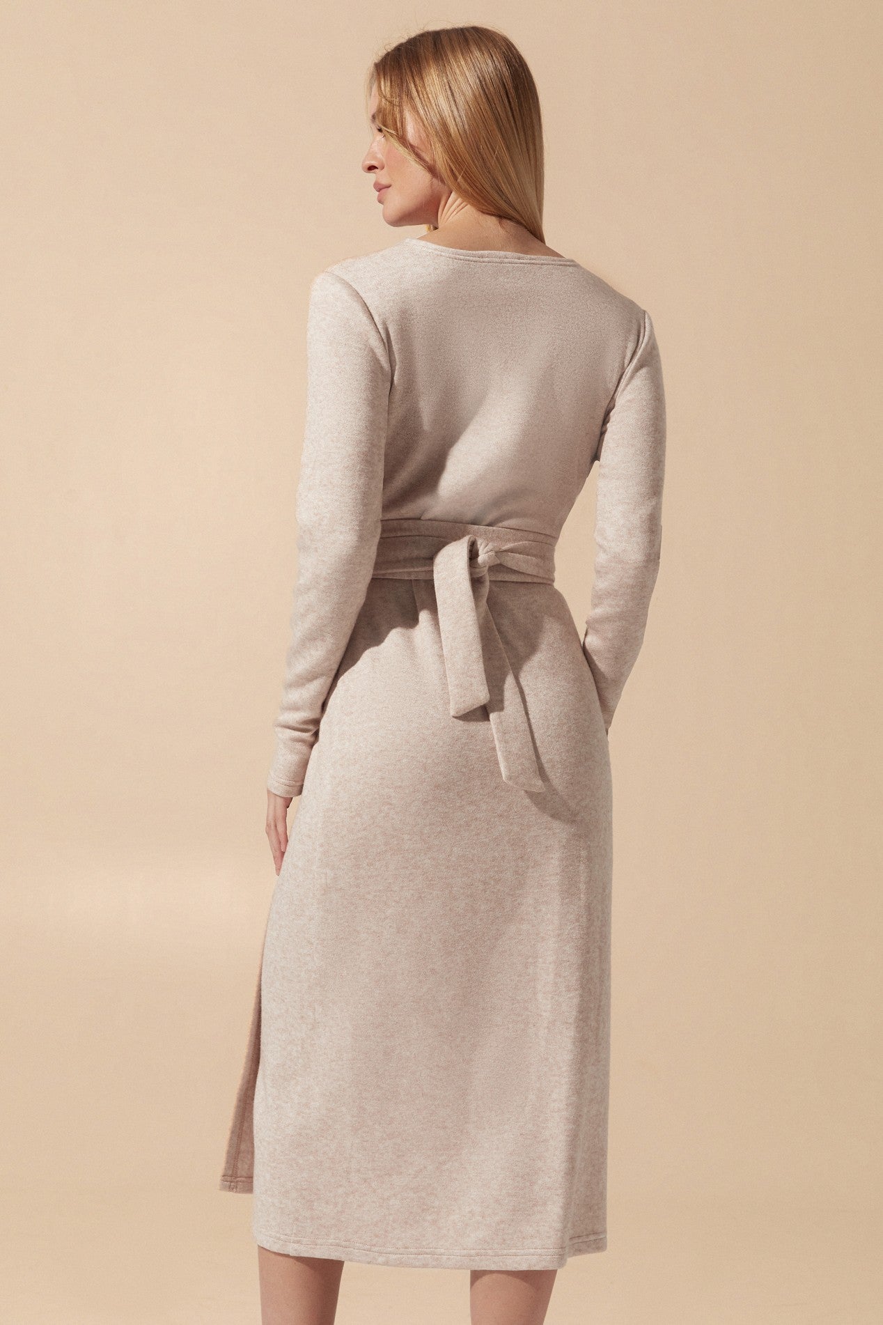 Back view of the Emberlyn Midi Dress in beige angora fabric with longsleeves, closed back and wrap around belt that goes around the waist