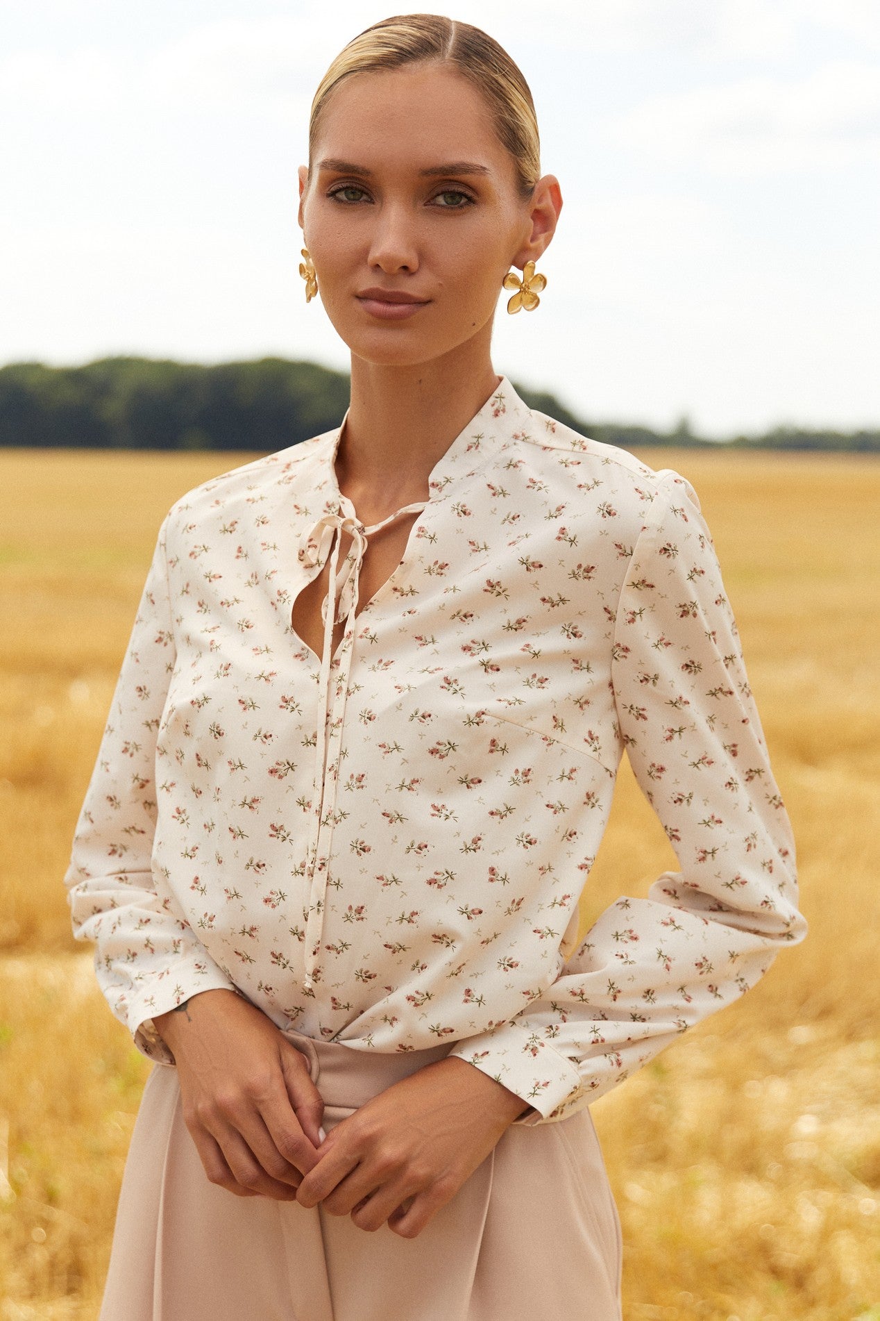 Close up of Floral Blouse by FemeAdor in white featuring a delicate floral print and tie detail, perfect for casual or polished looks