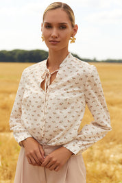 Close up of Floral Blouse by FemeAdor in white featuring a delicate floral print and tie detail, perfect for casual or polished looks