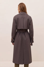 Back view of a dark gray belted trench coat with large bronze-toned buttons and a matching belt buckle, shown on a model.