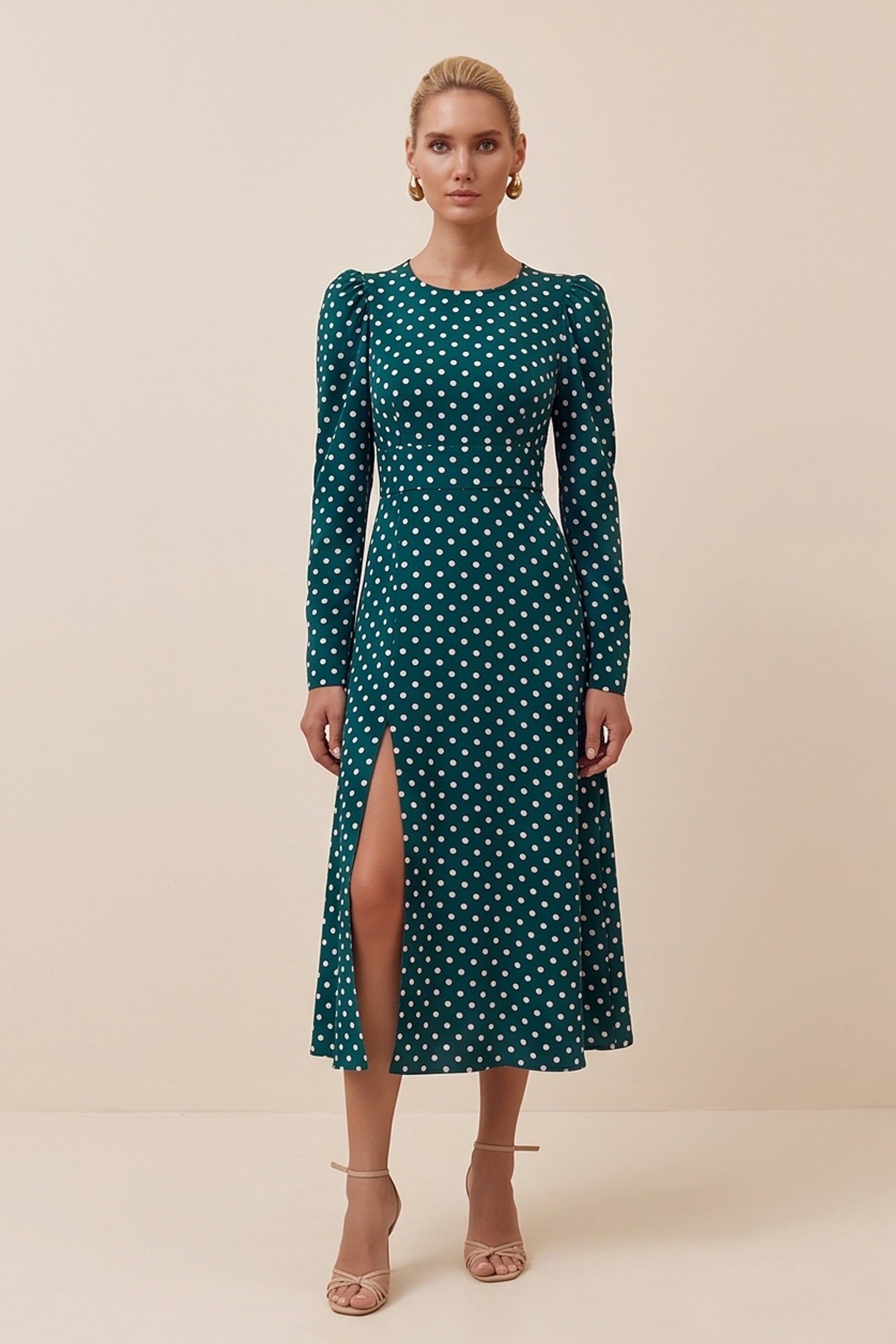 Front view of a woman wearing the green Emerald Midi Dress, elegant and sophisticated design with polka dots