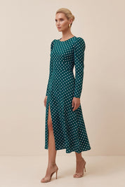 Side view of a woman wearing the green Emerald Midi Dress, elegant and sophisticated design with polka dots