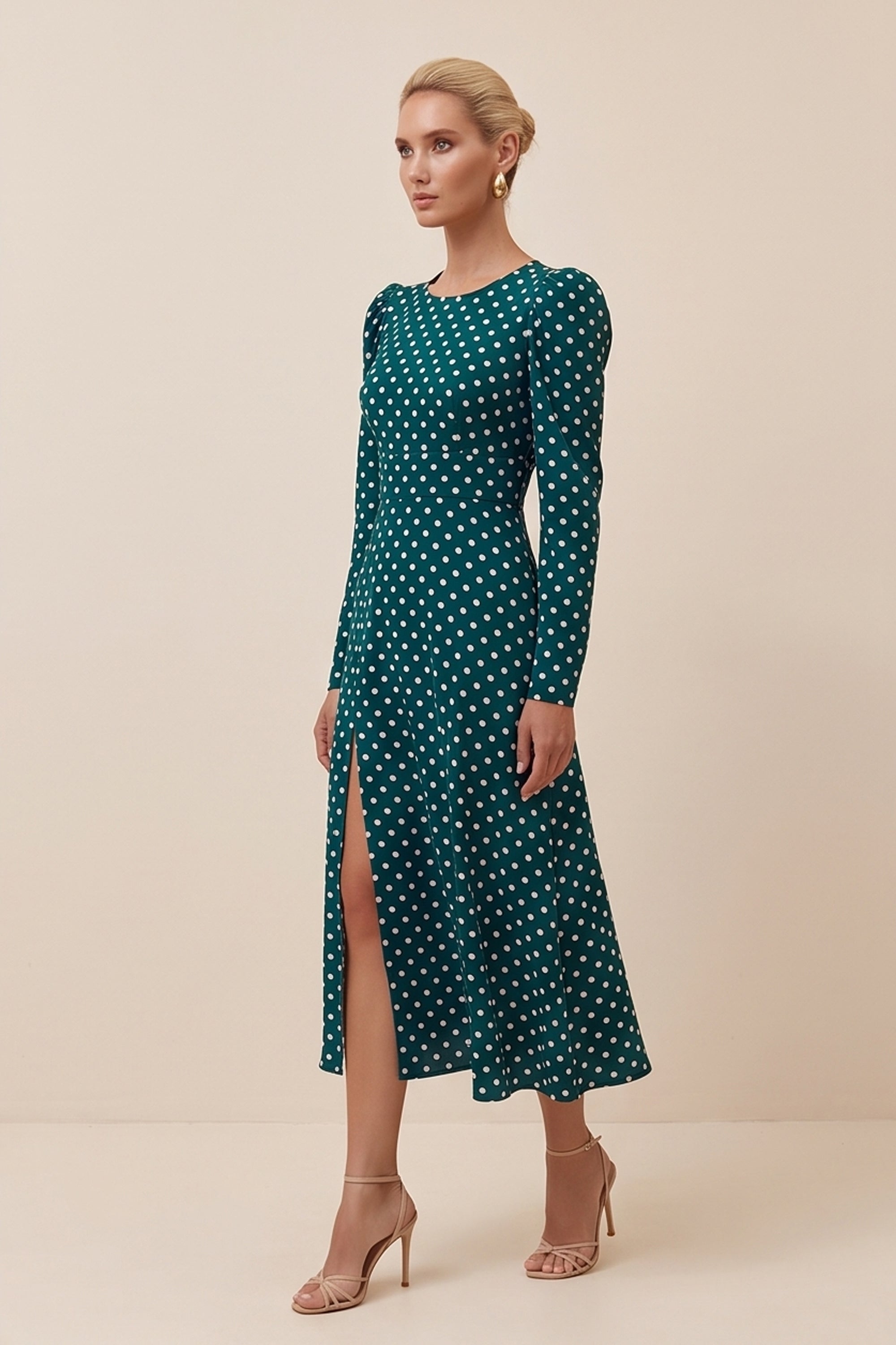 Side view of a woman wearing the green Emerald Midi Dress, elegant and sophisticated design with polka dots