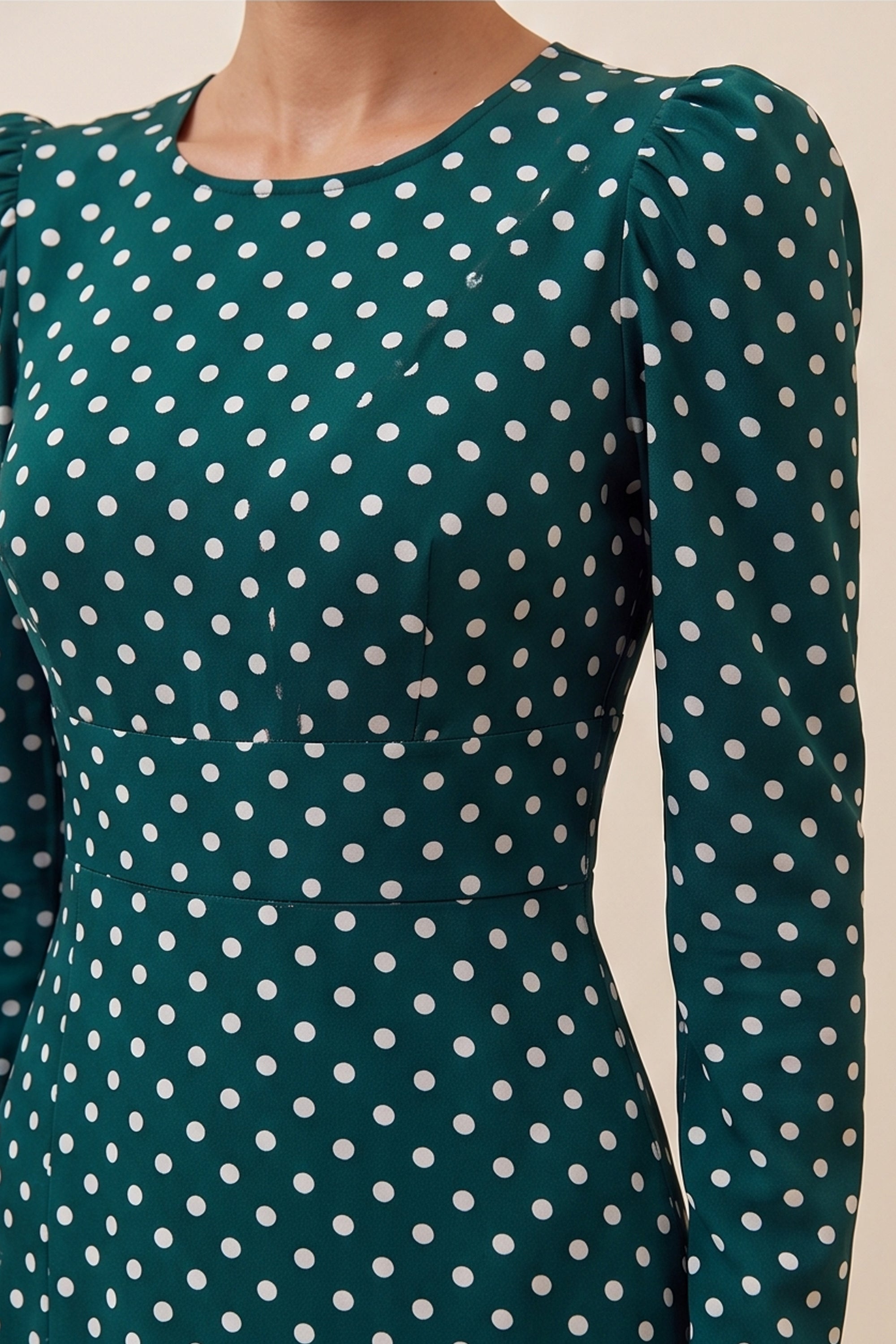 Close up view of a woman wearing the green Emerald Midi Dress, elegant and sophisticated design with polka dots