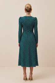 Back view of a woman wearing the green Emerald Midi Dress, elegant and sophisticated design with polka dots