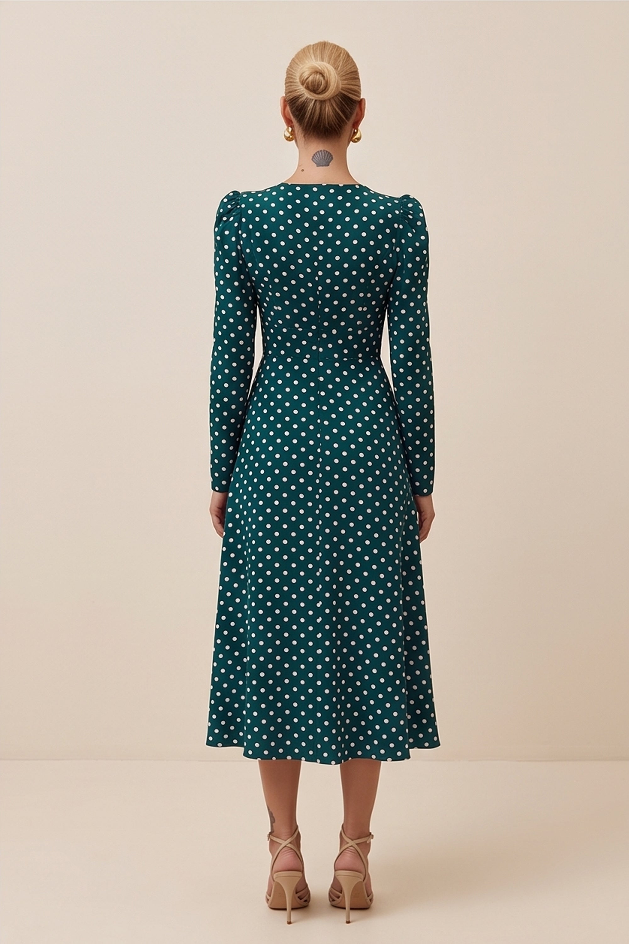 Back view of a woman wearing the green Emerald Midi Dress, elegant and sophisticated design with polka dots
