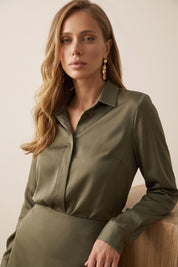 Close up view of a woman wearing the green satin Nora Blouse with silk-like sheen and flattering drape, perfect for work or special occasions