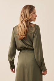 Front view of a woman wearing the green satin Nora Blouse with silk-like sheen and flattering drape, perfect for work or special occasions