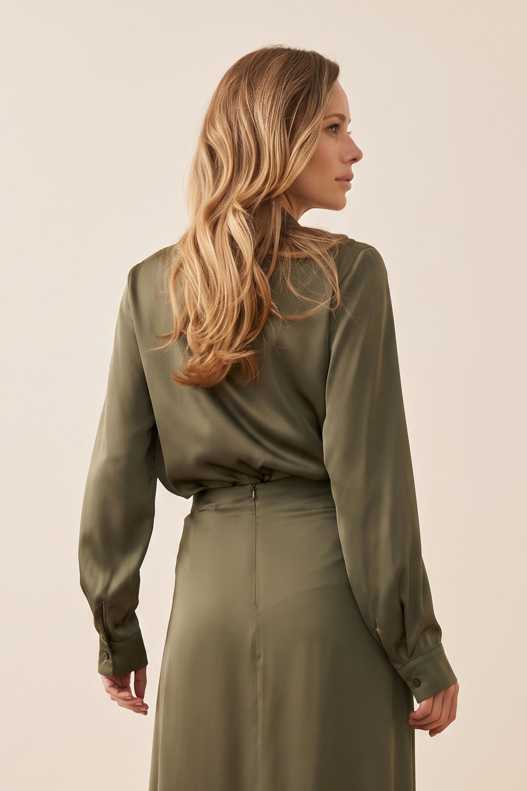 Front view of a woman wearing the green satin Nora Blouse with silk-like sheen and flattering drape, perfect for work or special occasions