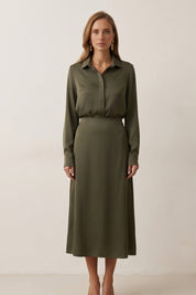 Woman wearing the Nora Skirt by FemeAdor in green featuring a silk-like finish and flattering midi silhouette, ideal for various occasions