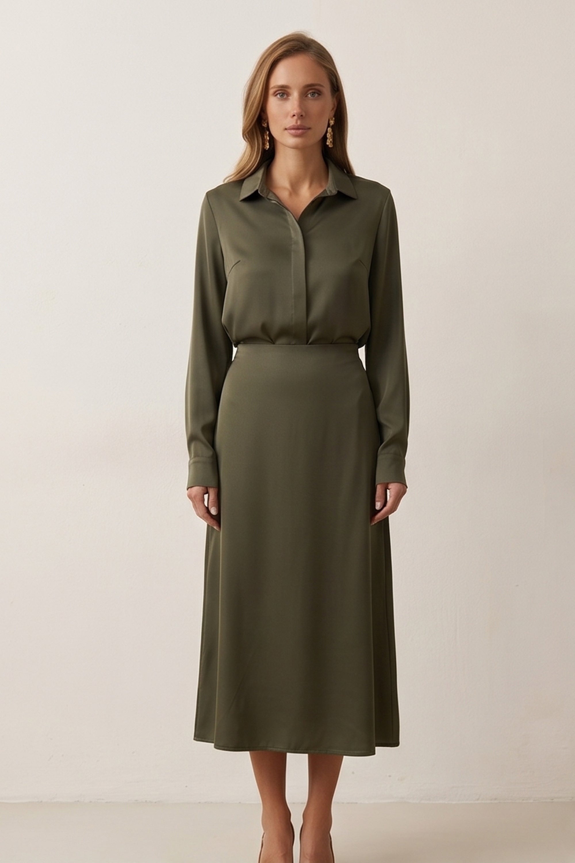 Woman wearing the Nora Skirt by FemeAdor in green featuring a silk-like finish and flattering midi silhouette, ideal for various occasions
