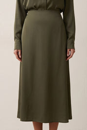 Close up view of Nora Skirt by FemeAdor in green featuring a silk-like finish and flattering midi silhouette, ideal for various occasions