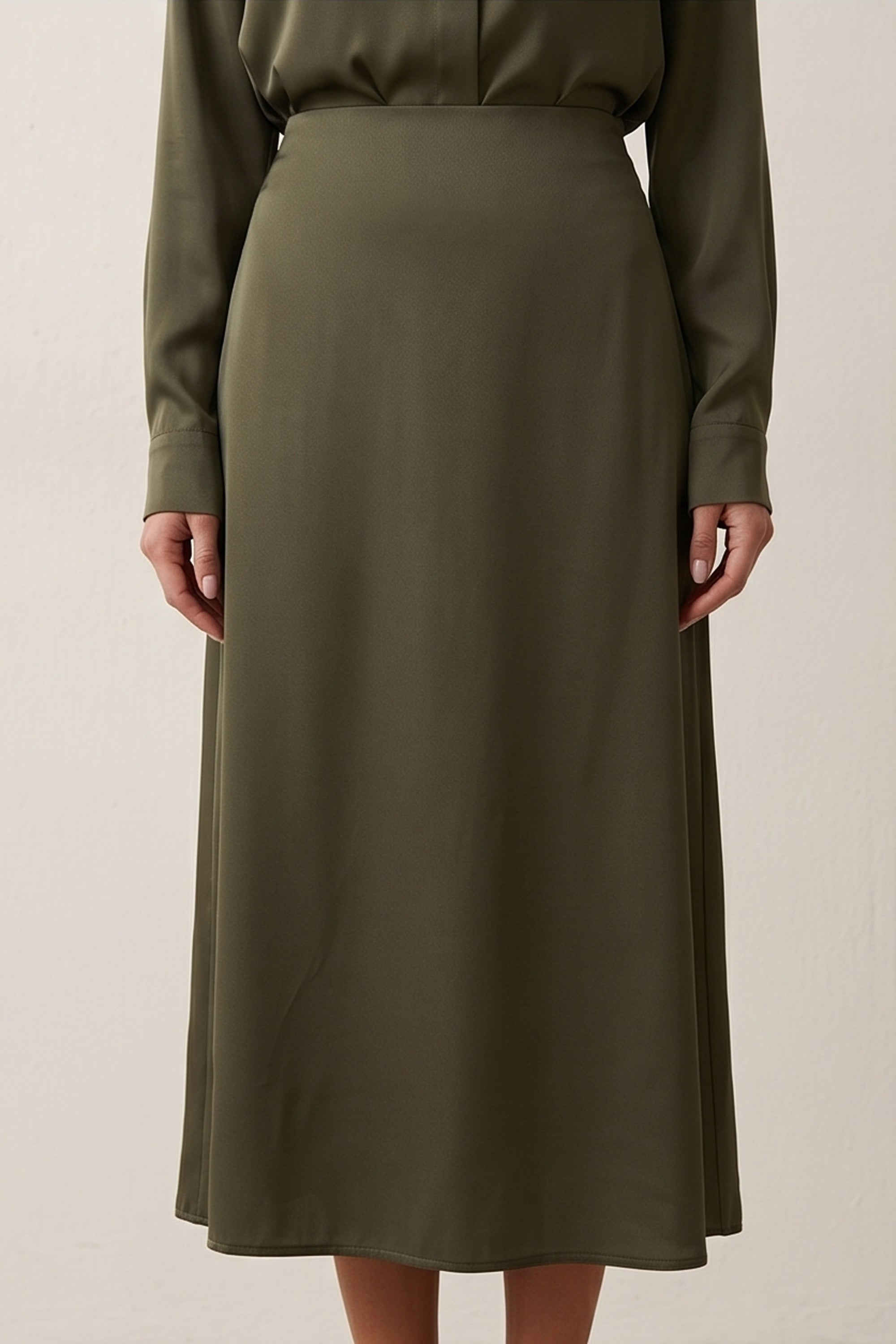 Close up view of Nora Skirt by FemeAdor in green featuring a silk-like finish and flattering midi silhouette, ideal for various occasions