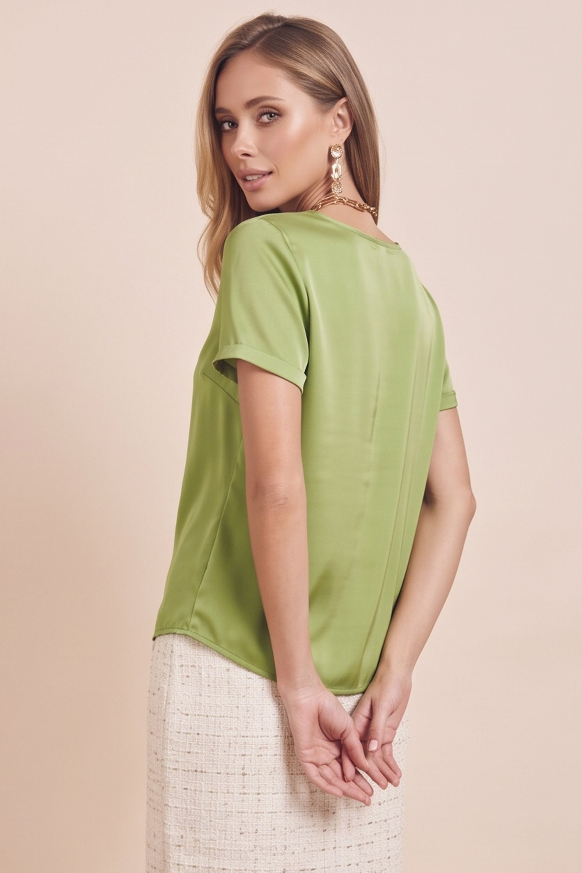 Side view of a woman wearing the green Pearl T-shirt by FemeAdor with silk-like finish and relaxed flattering fit