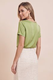 Back view of a woman wearing the green Pearl T-shirt by FemeAdor with silk-like finish and relaxed flattering fit