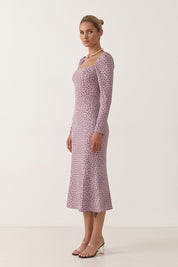Side view of a woman wearing the pink Celestra Midi Dress by FemeAdor featuring a flattering fit-and-flare silhouette and timeless polka dot pattern